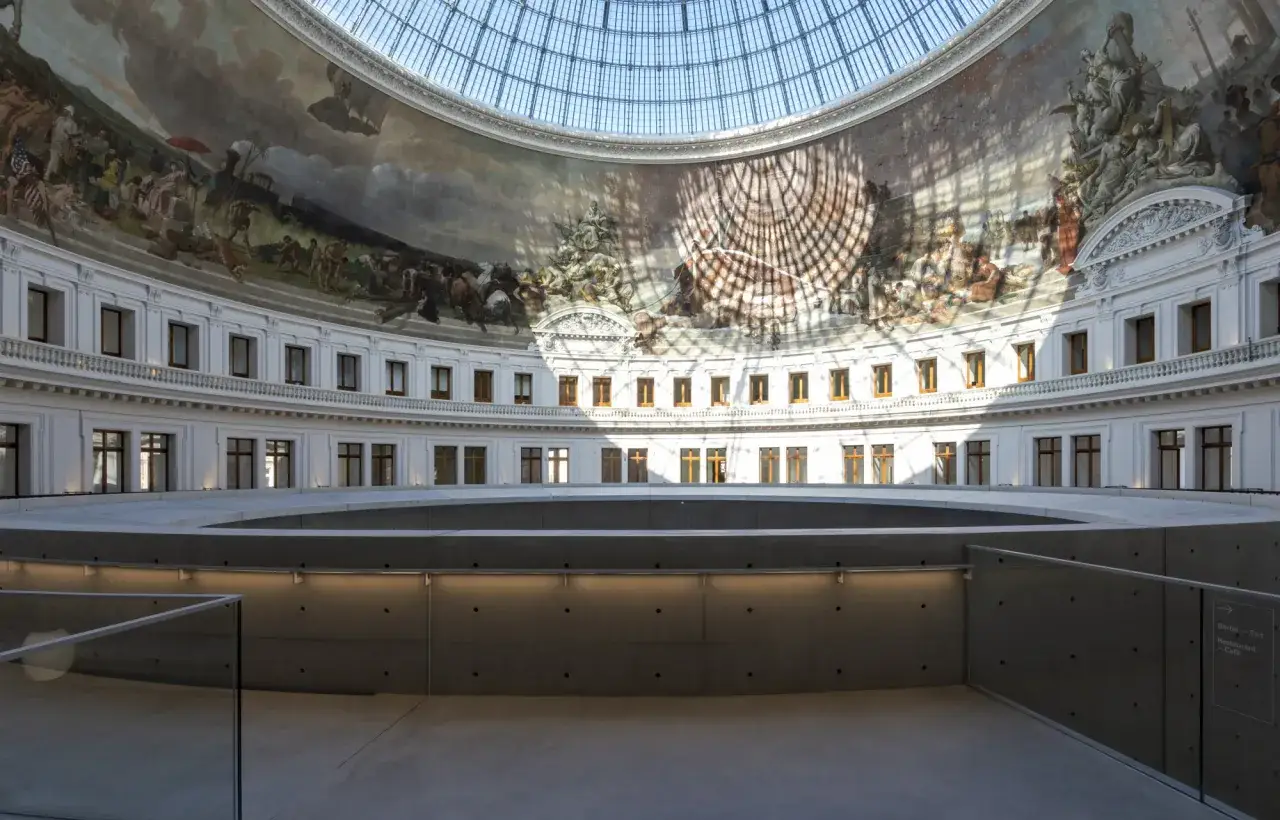 Intérieur de la Bourse Pinault, avec sa coupole vitrée, ses fresques monumentales et sa structure moderne en béton.
