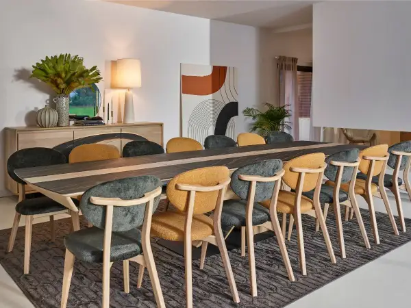Salle à manger élégante, parfaite pour un restaurant gastronomique à Paris. Table en bois et céramique, chaises confortables aux couleurs chaudes et sombres.