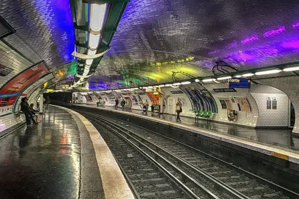 Le quai du métro Arts et Métiers, illuminé par des lumières colorées rappelant un atelier des lumières, attend les voyageurs.