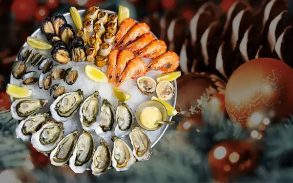 Plateau de fruits de mer frais, une tradition de Noël en France, avec huîtres, crevettes, moules et bigorneaux, sur un lit de glace, décoré de citrons et d'une sauce.