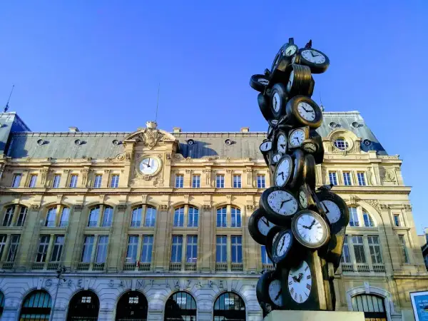 Sculpture de multiples horloges devant la gare Saint-Lazare, un monument parisien où le temps s'est arrêté.