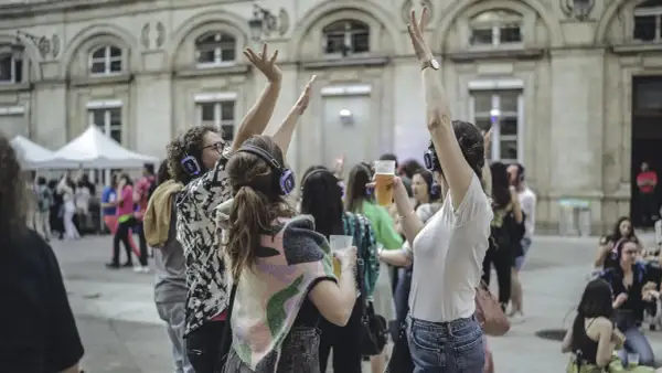 Des gens dansent avec des casques lors d'un concert silencieux devant l'Hôtel de Ville de Paris.