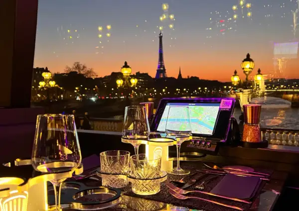 Vue sur Paris au crépuscule, avec la Tour Eiffel illuminée. Une table dressée pour un dîner romantique, parfaite pour savoir où manger après minuit.