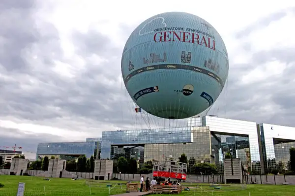 Ballon dirigeable "Générali" survolant Paris, avec la Mairie de Paris et Air Parif inscrits sur sa surface.