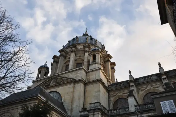 Dôme majestueux de l'église du Val-de-Grâce, se détachant sur un ciel nuageux. L'architecture baroque est impressionnante.